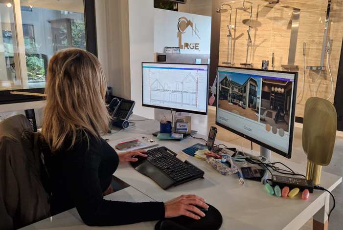 Une architecte RGE 35 travaillant sur les plans de rénovation d'une maison à Saint-Malo